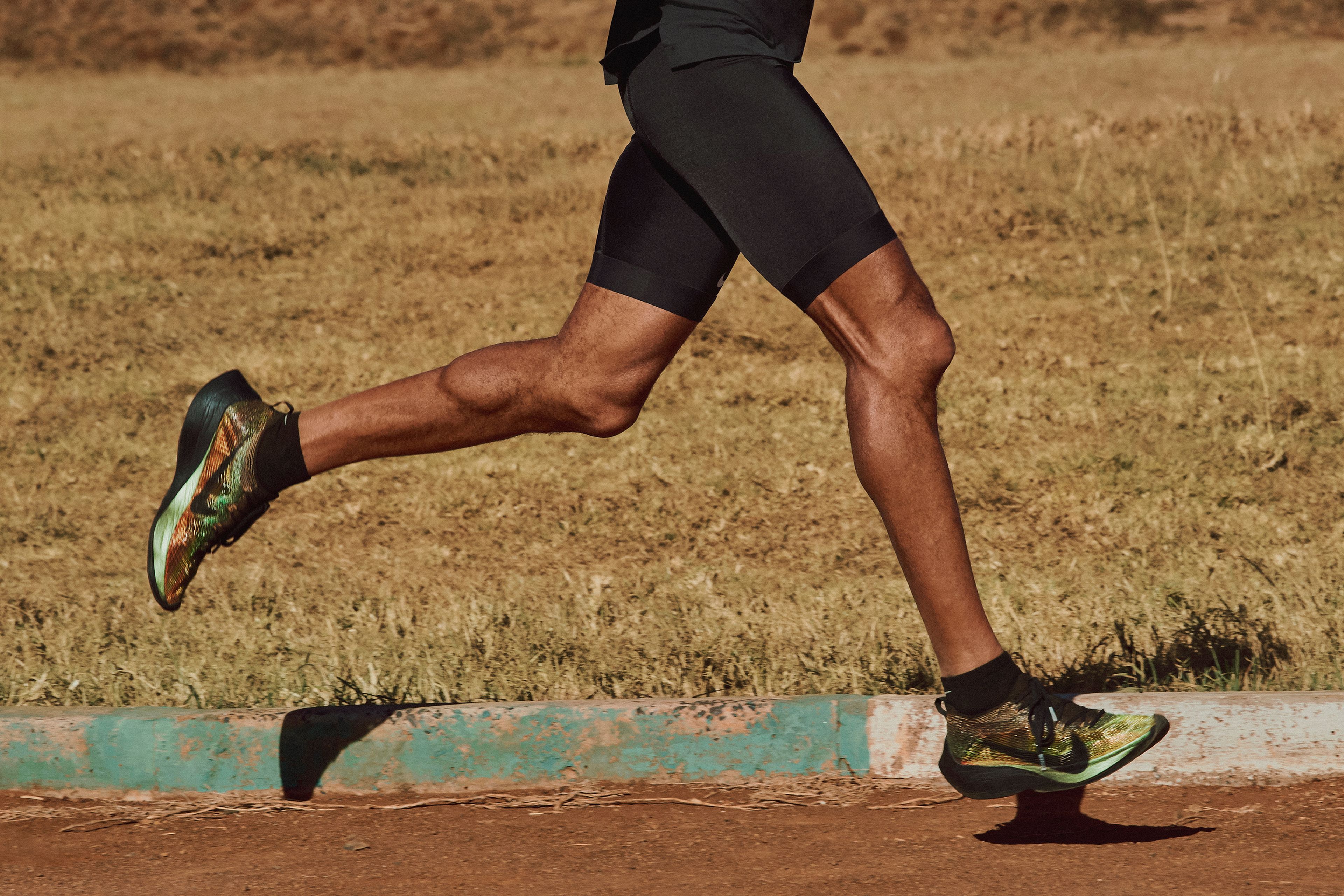 Athlete's legs mid-stride in Nike Zoom Vaporfly Elite Vaperprint shoes with iridescent green color.