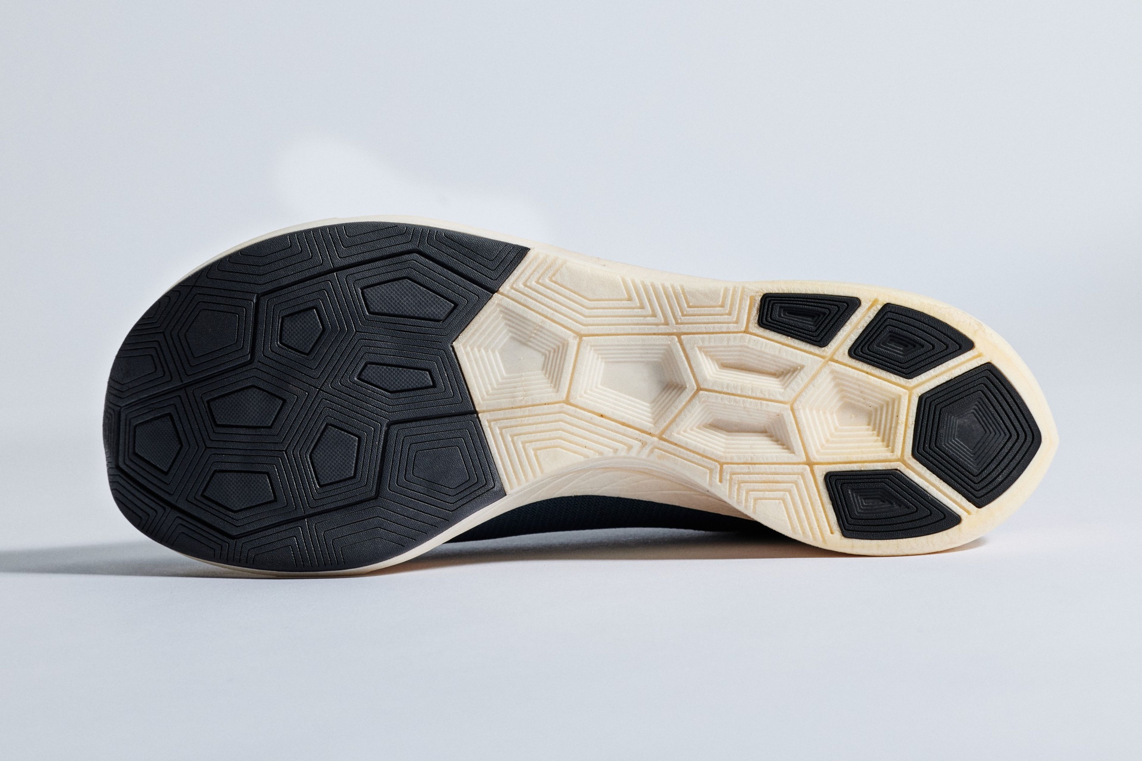 Bottom view of a Nike Zoom Vaporfly 4% running shoe showing the black and cream rubber outsole with geometric traction pattern.