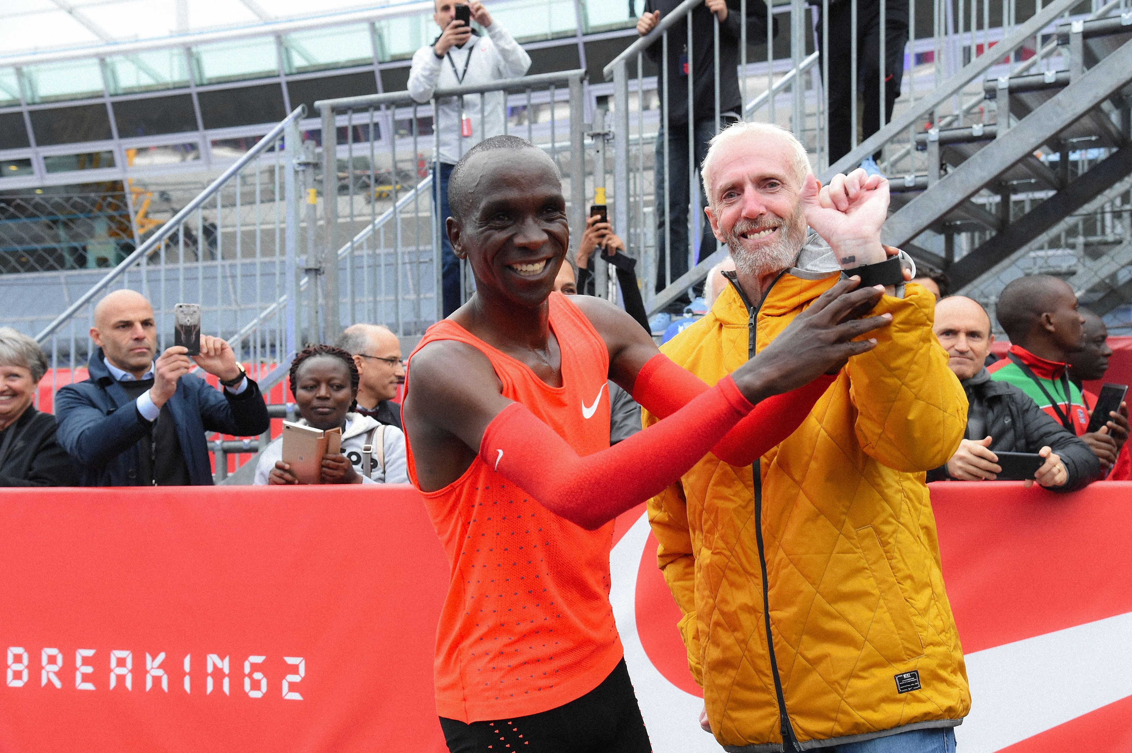 Eliud Kipchoge smiling with Sandy Bodecker at a Nike Breaking2 event.