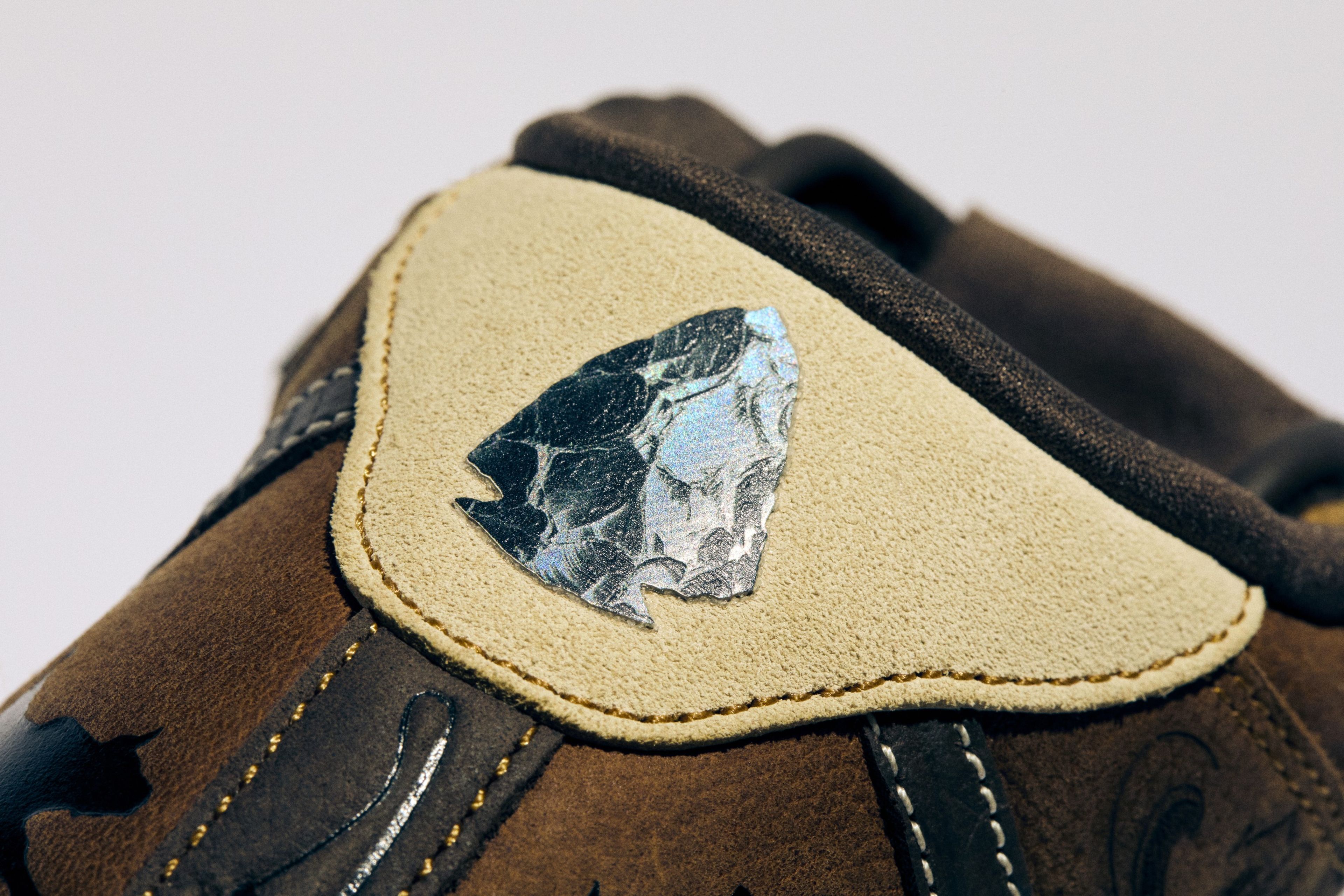An obsidian arrowhead graphic on the heel of the Nike Air Force 1 Mid.