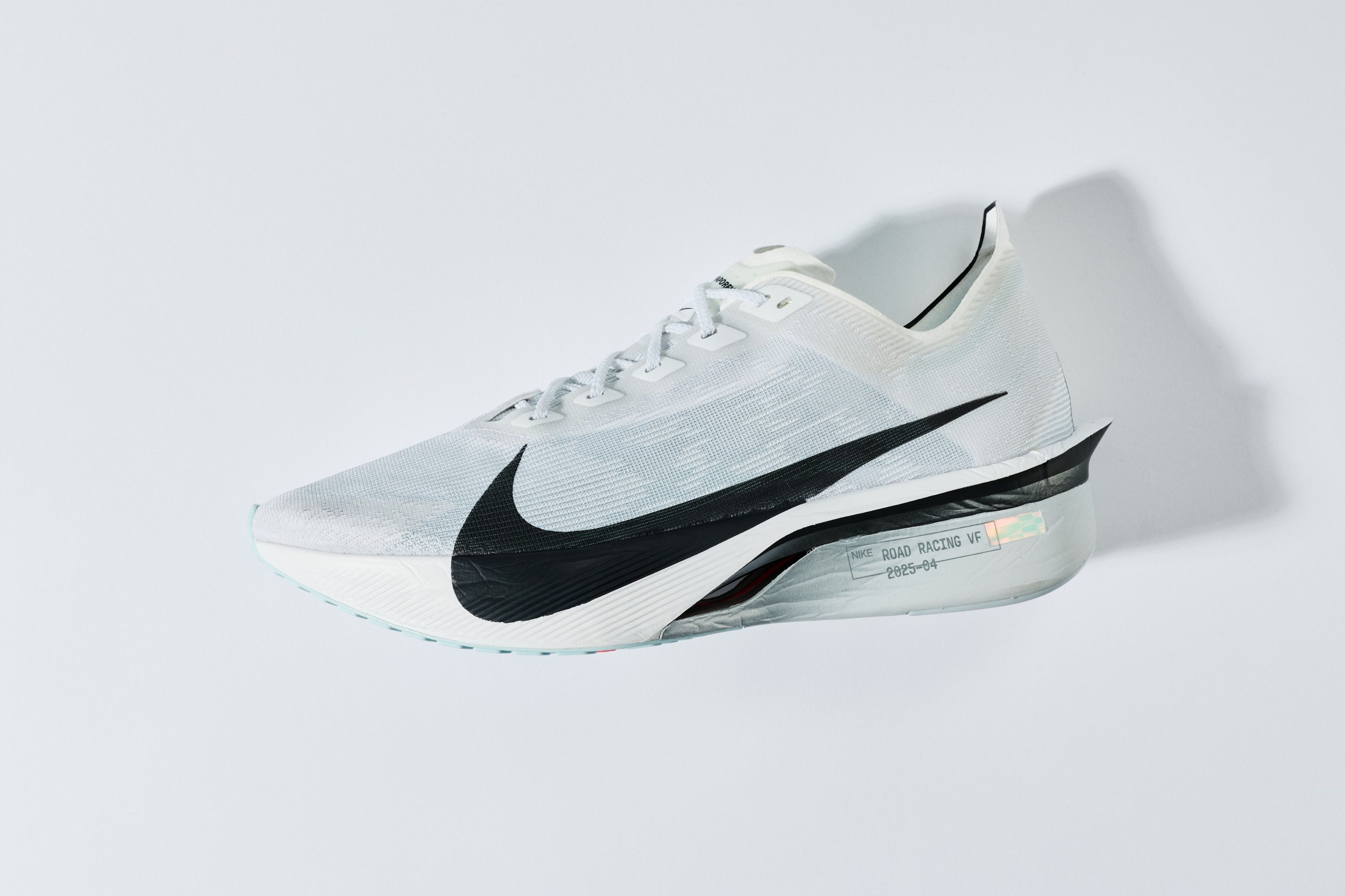 Nike Vaporfly 4 running shoe in white and black colorway with large Nike Swoosh and iridescent midsole detail on light gray background.