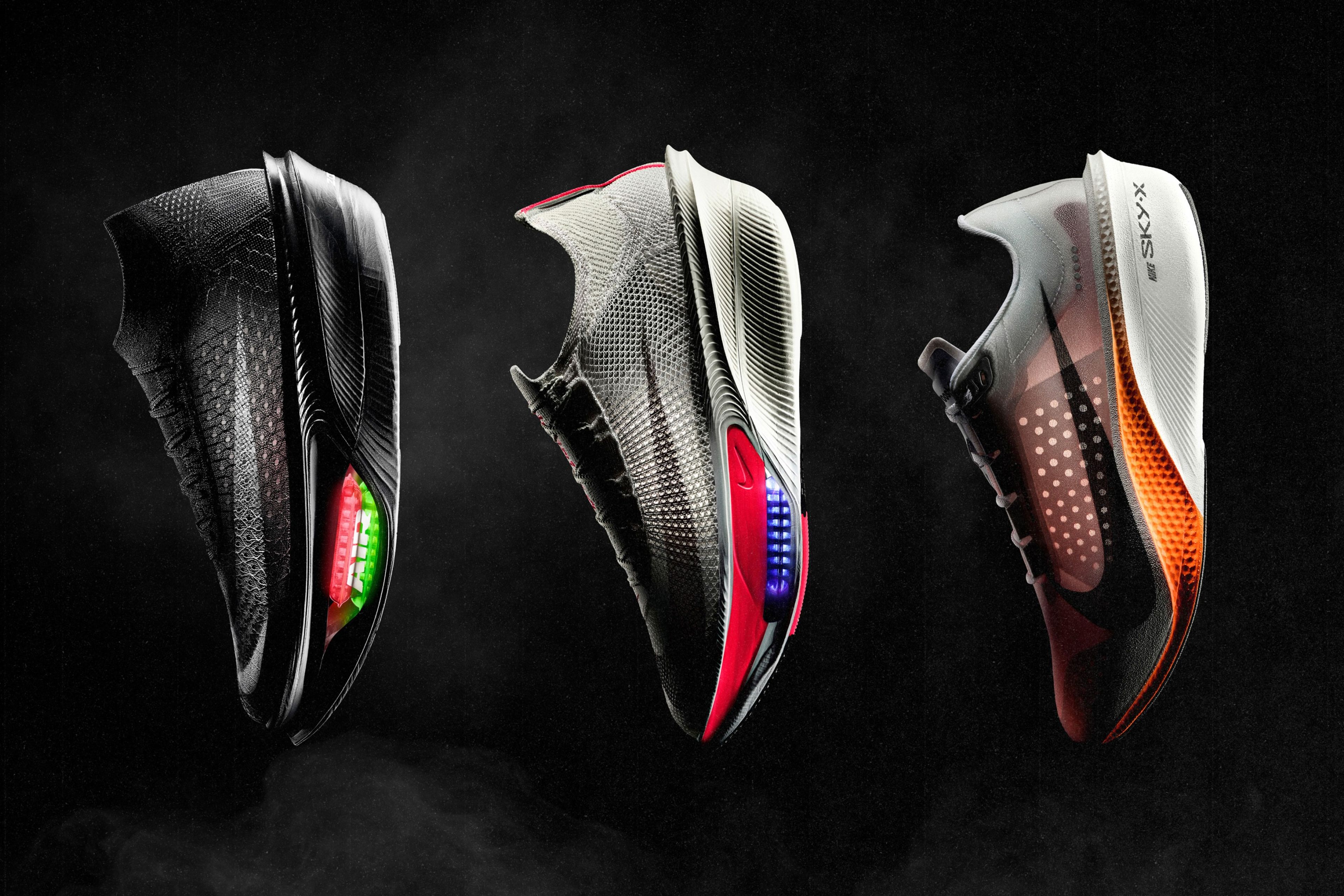 Three Nike running shoes on dark background: a black Apex with glowing Air Zoom, gray Alphafly 4 with red and blue midsole accents, and Swooshfly with an orange midsole