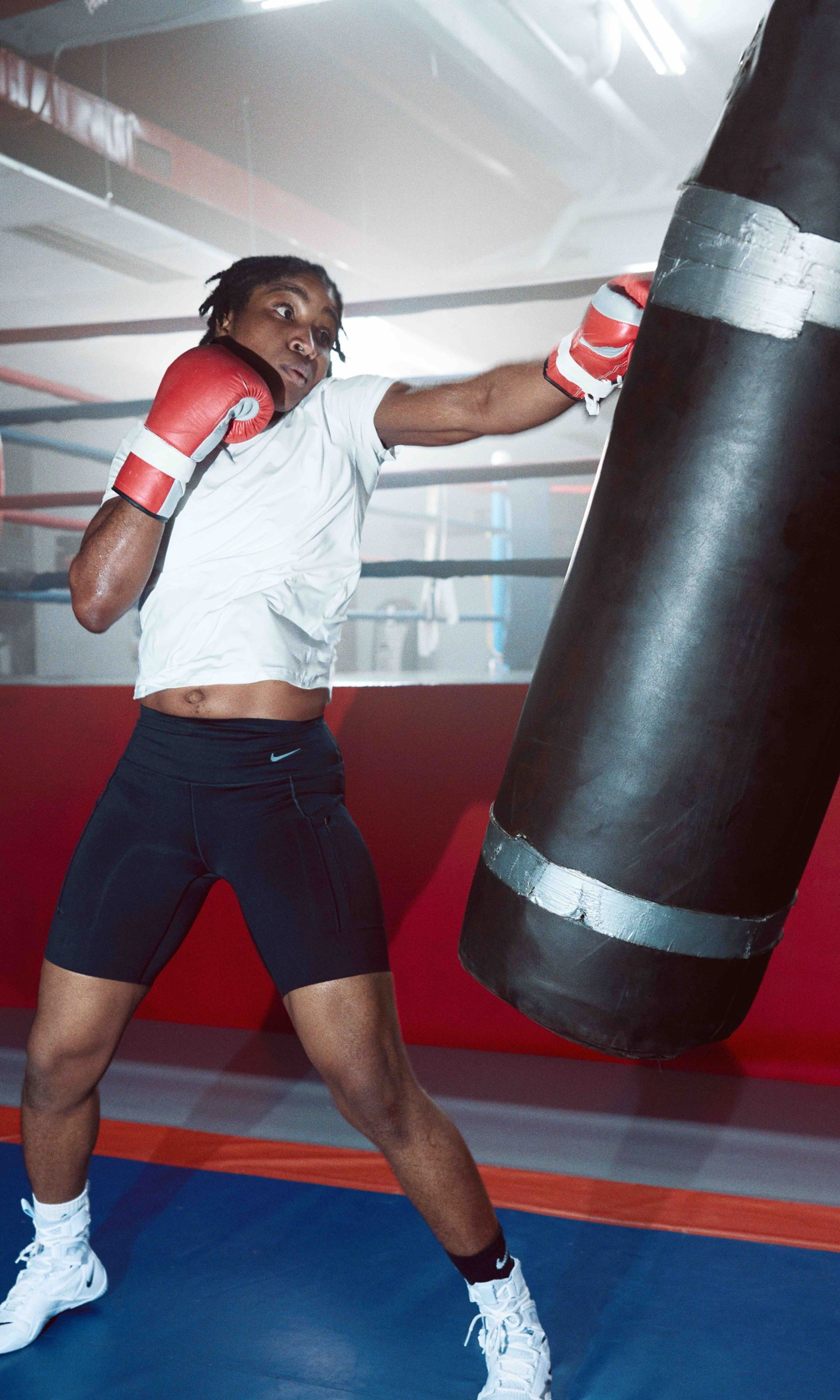 Cindy Ngamba at a boxing gym throwing a left jab at a swinging punching bag.