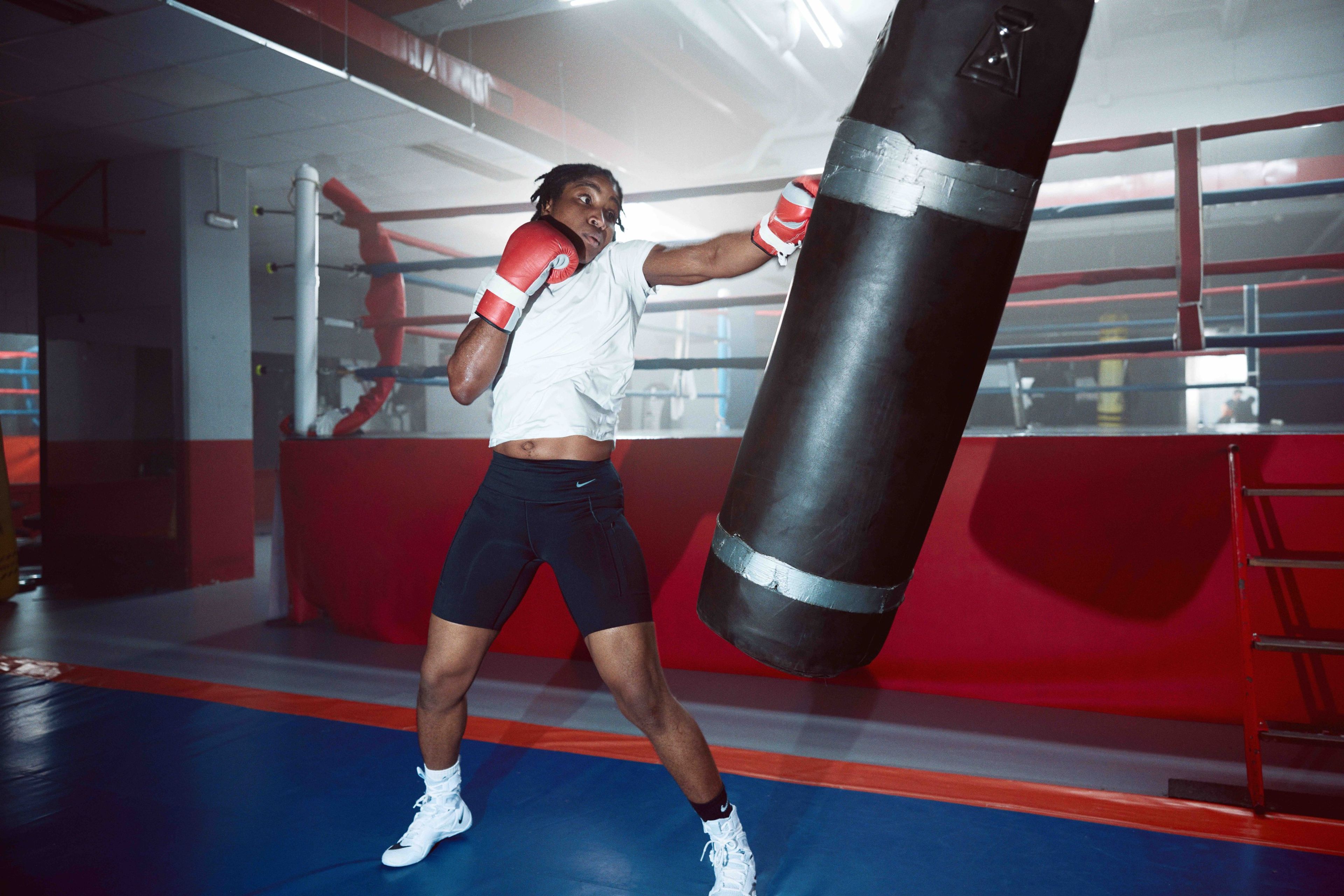 Cindy Ngamba at a boxing gym throwing a left jab at a swinging punching bag.
