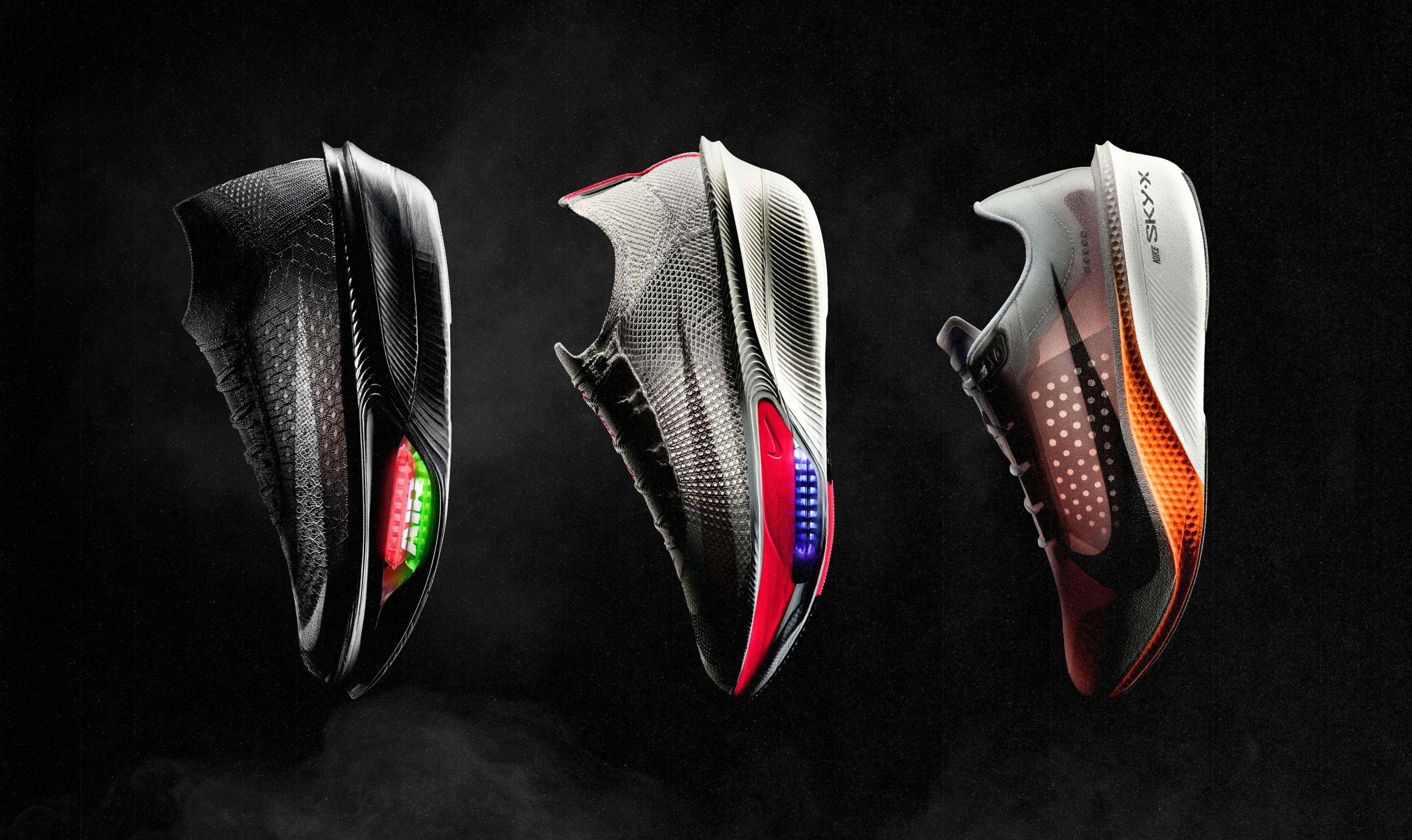 Three Nike running shoes on dark background: a black Apex with glowing Air Zoom, gray Alphafly 4 with red and blue midsole accents, and Swooshfly with an orange midsole