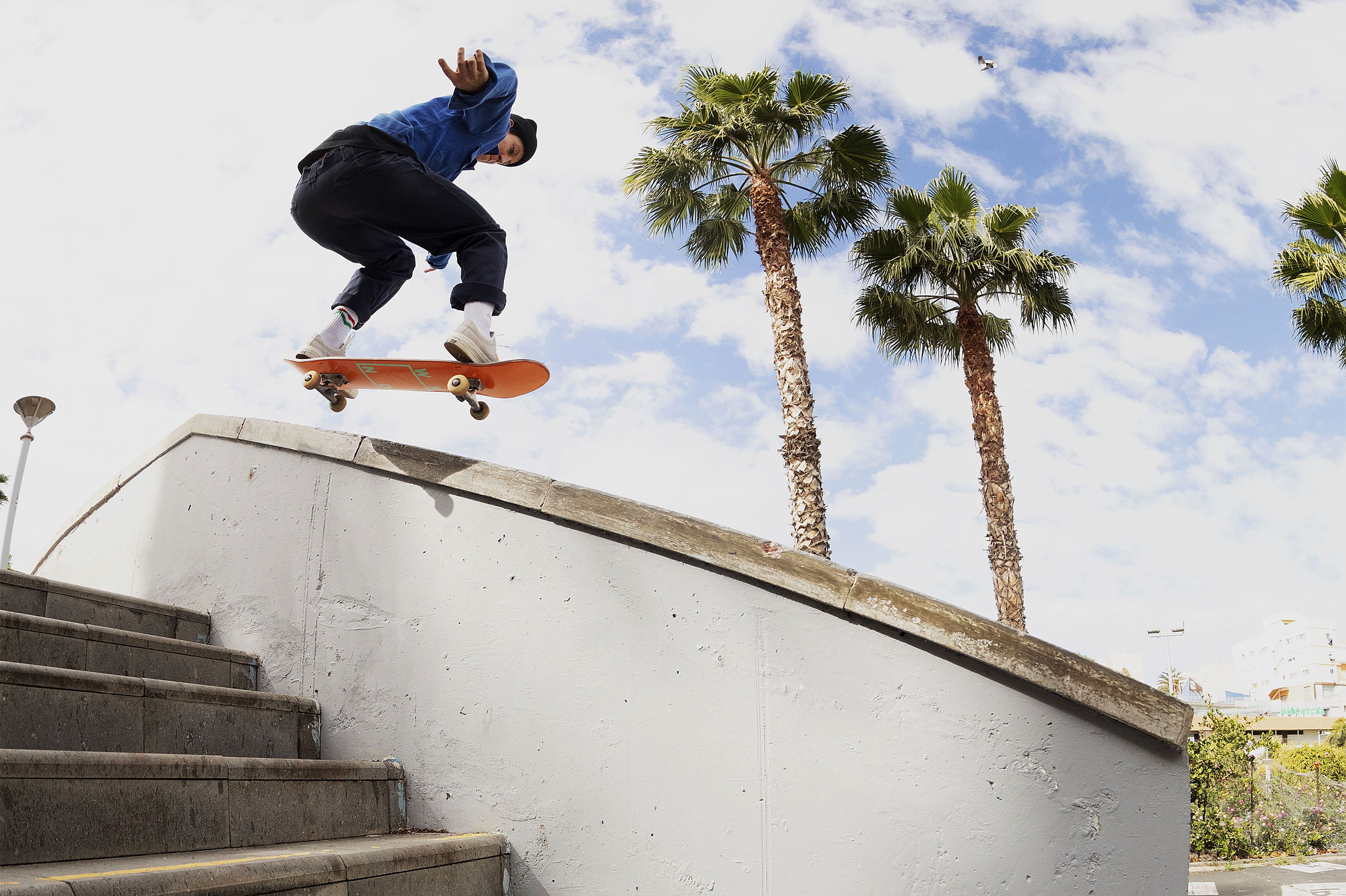 Alexis Sable mid air on her skateboard going over a set of stairs.