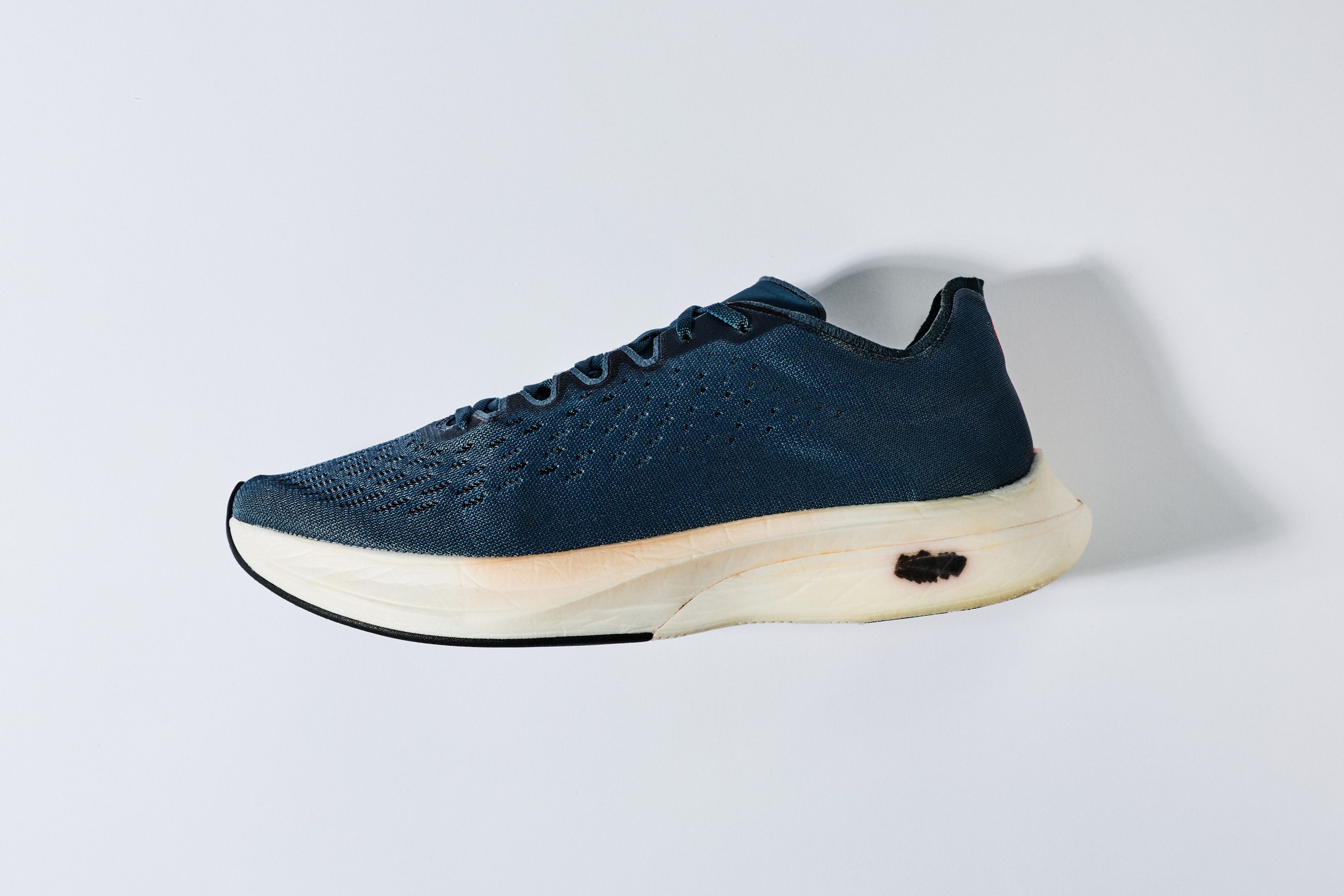 Prototype Nike Zoom Air Vaporfly 4% performance running shoe with knit upper, thick cream foam midsole, and black outsole on a light gray background.