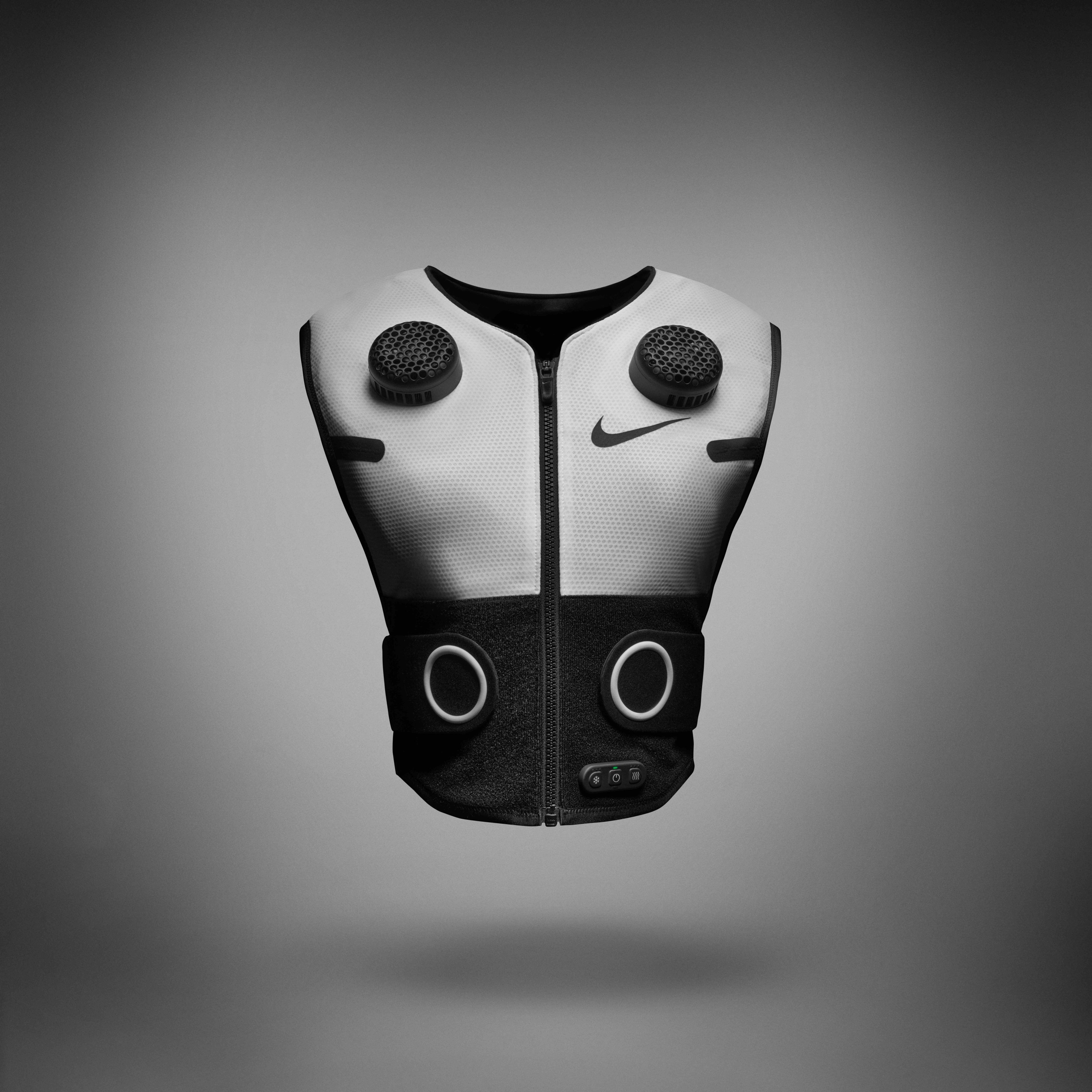 Front view of Nike x Hyperice Vest, shown in white with black thermal modules and compression tabs. Vest floats above a grey background, casting a shadow underneath.