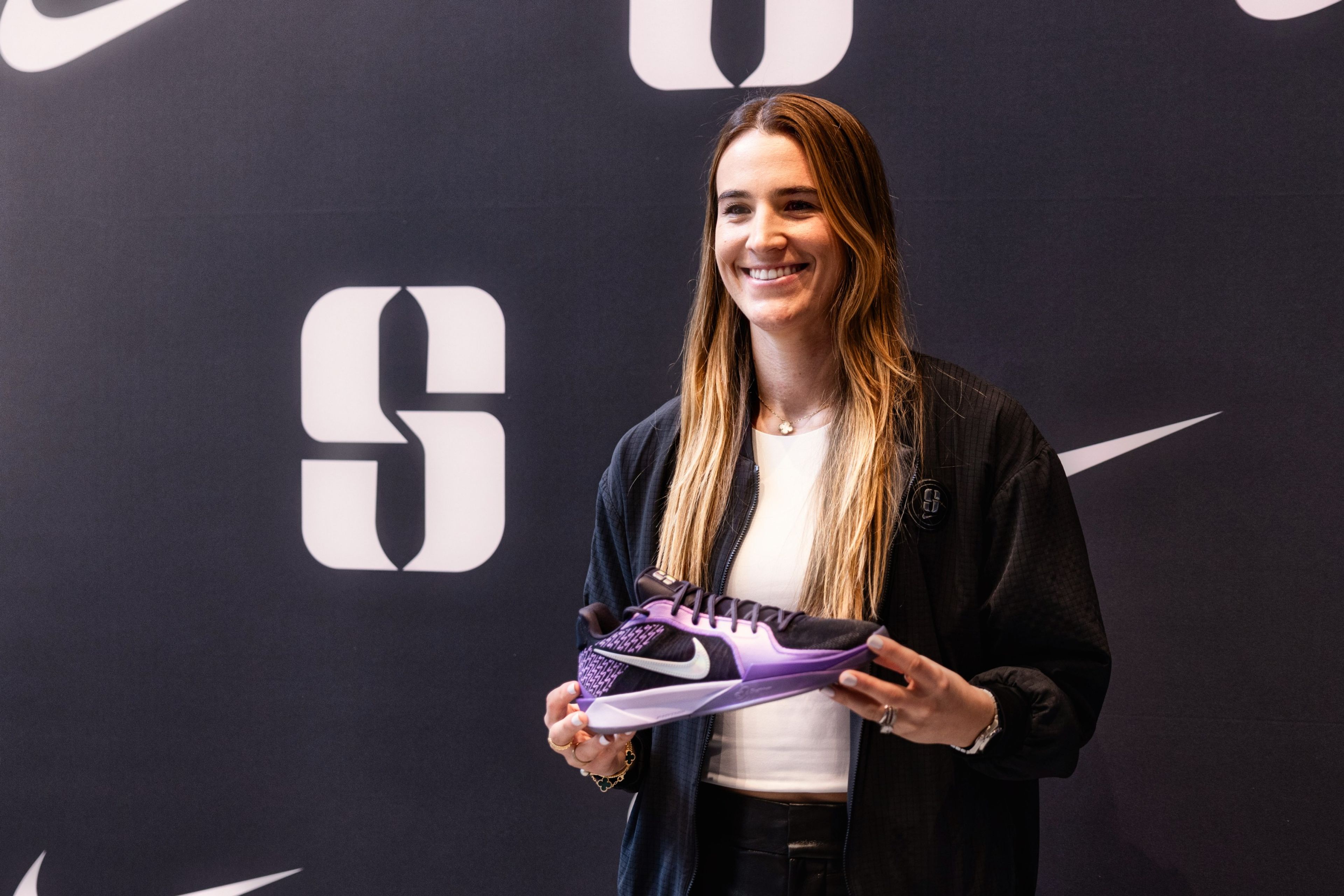 Sabrina Ionesco holding the Sabrina 2 shoe in black and purple at the collection launch in New York City