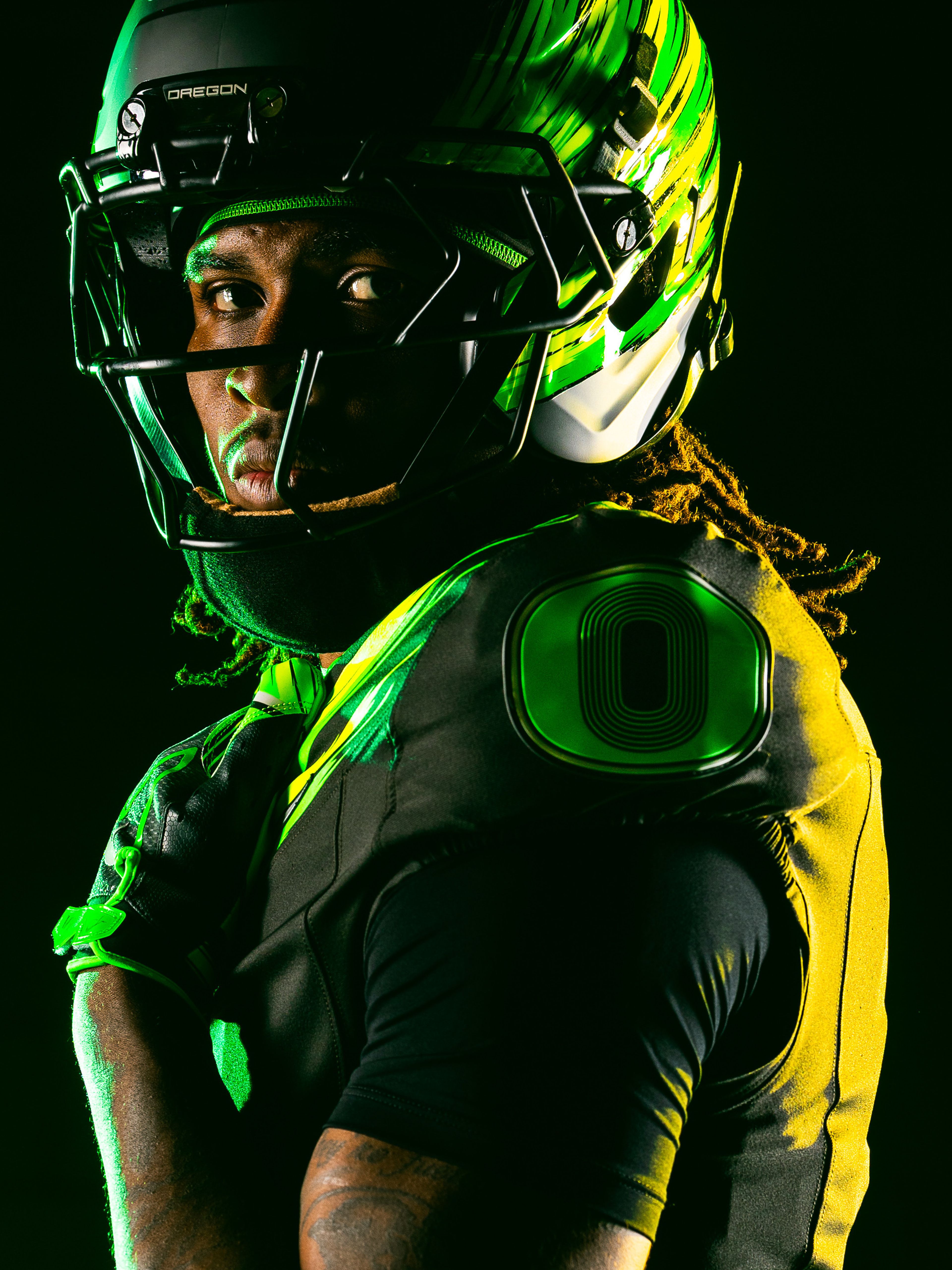 An Oregon Ducks football player wearing a high-visibility with reflective silver accents.