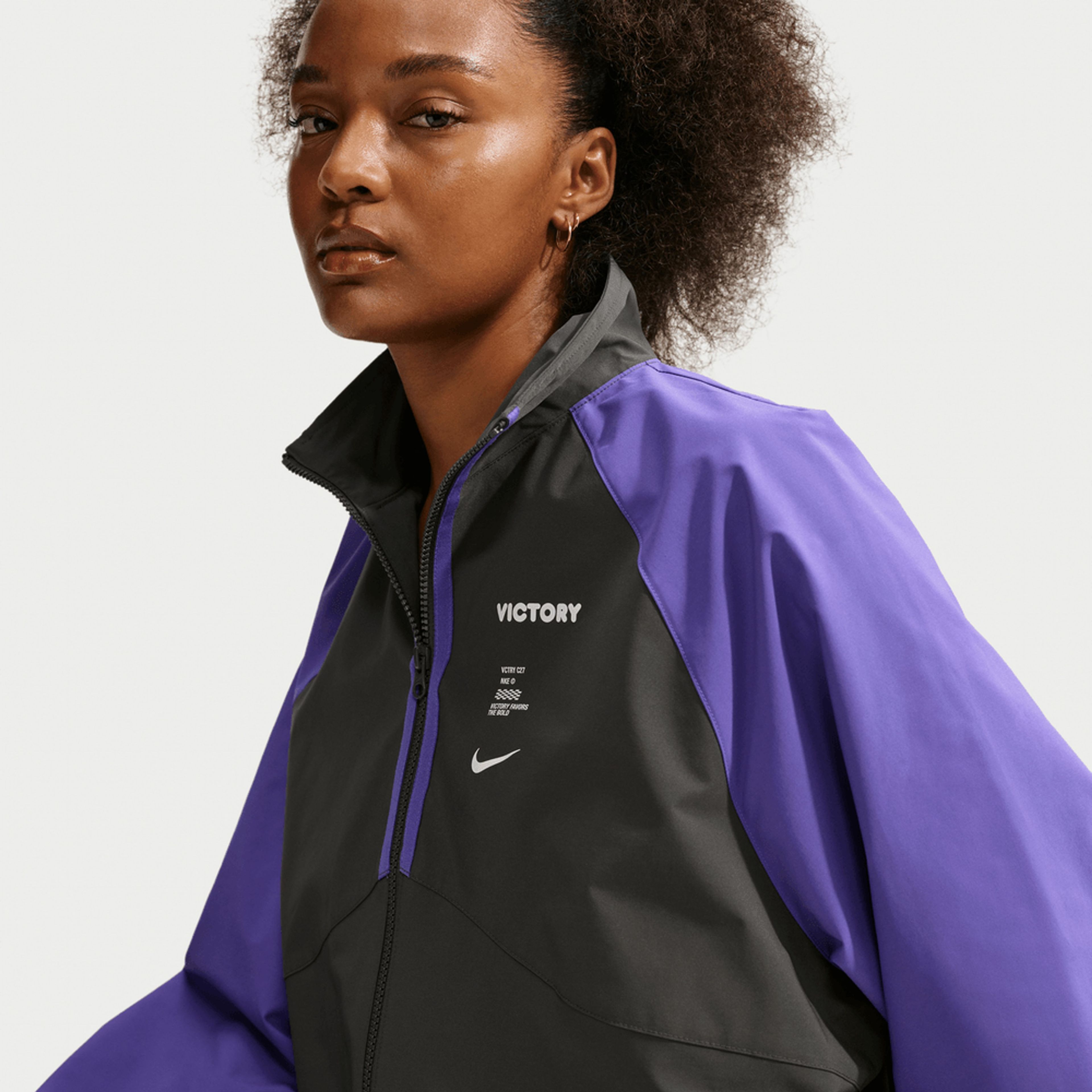 Woman wearing a black and purple Nike Victory Collection jacket