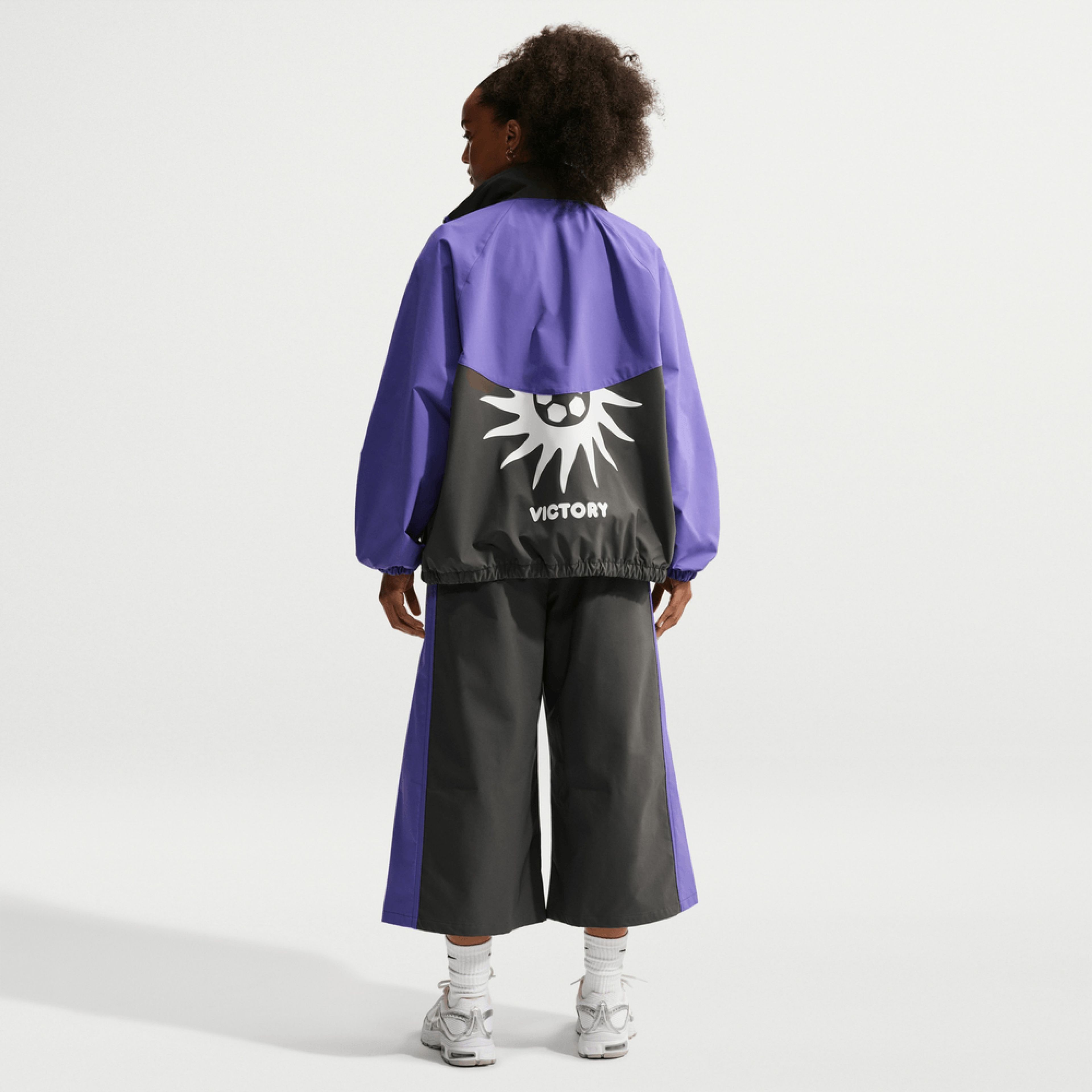 Woman wearing a black and purple Nike Victory Collection jacket