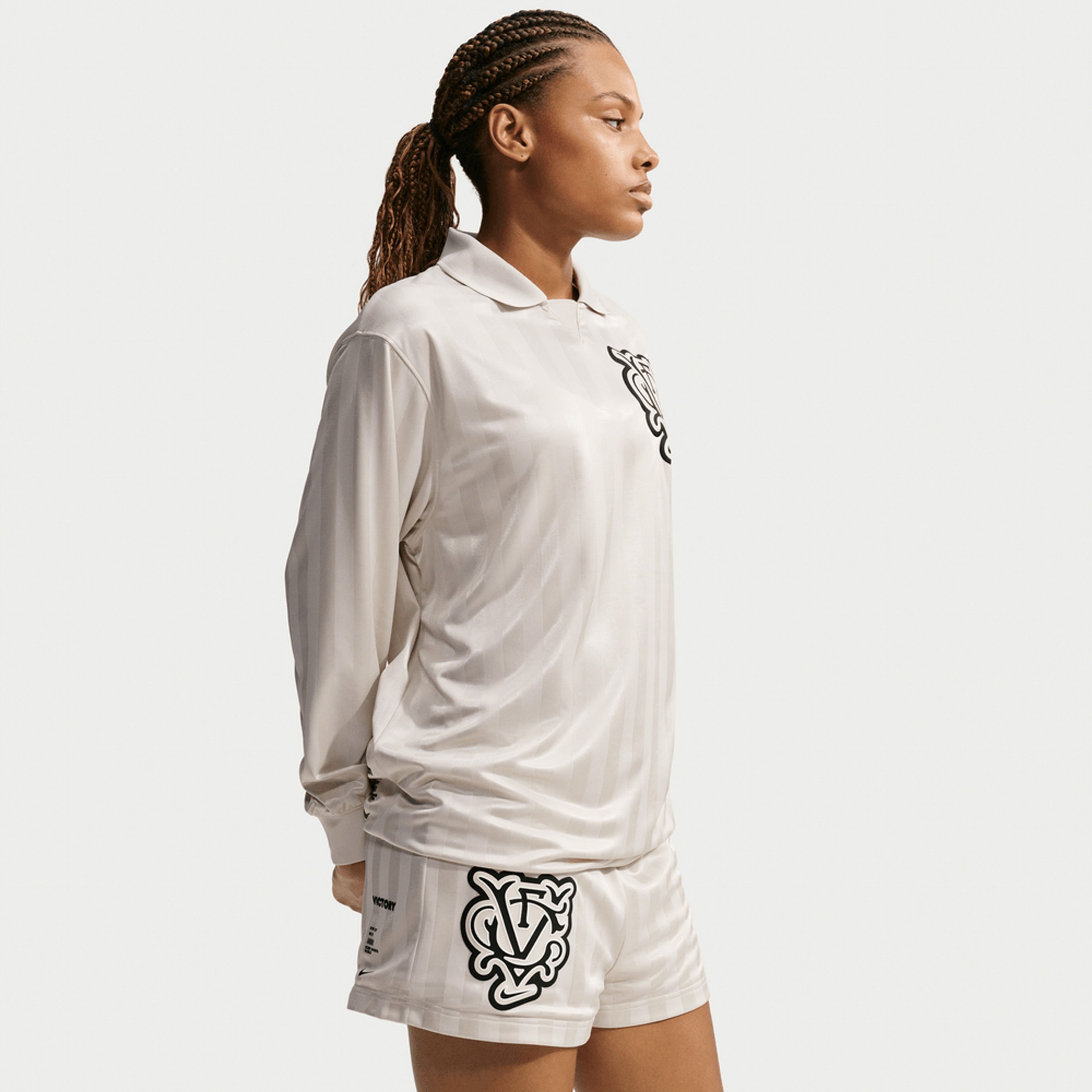 Woman wearing a Nike Victory Collection oversize long-sleeve polo jersey and matching shorts