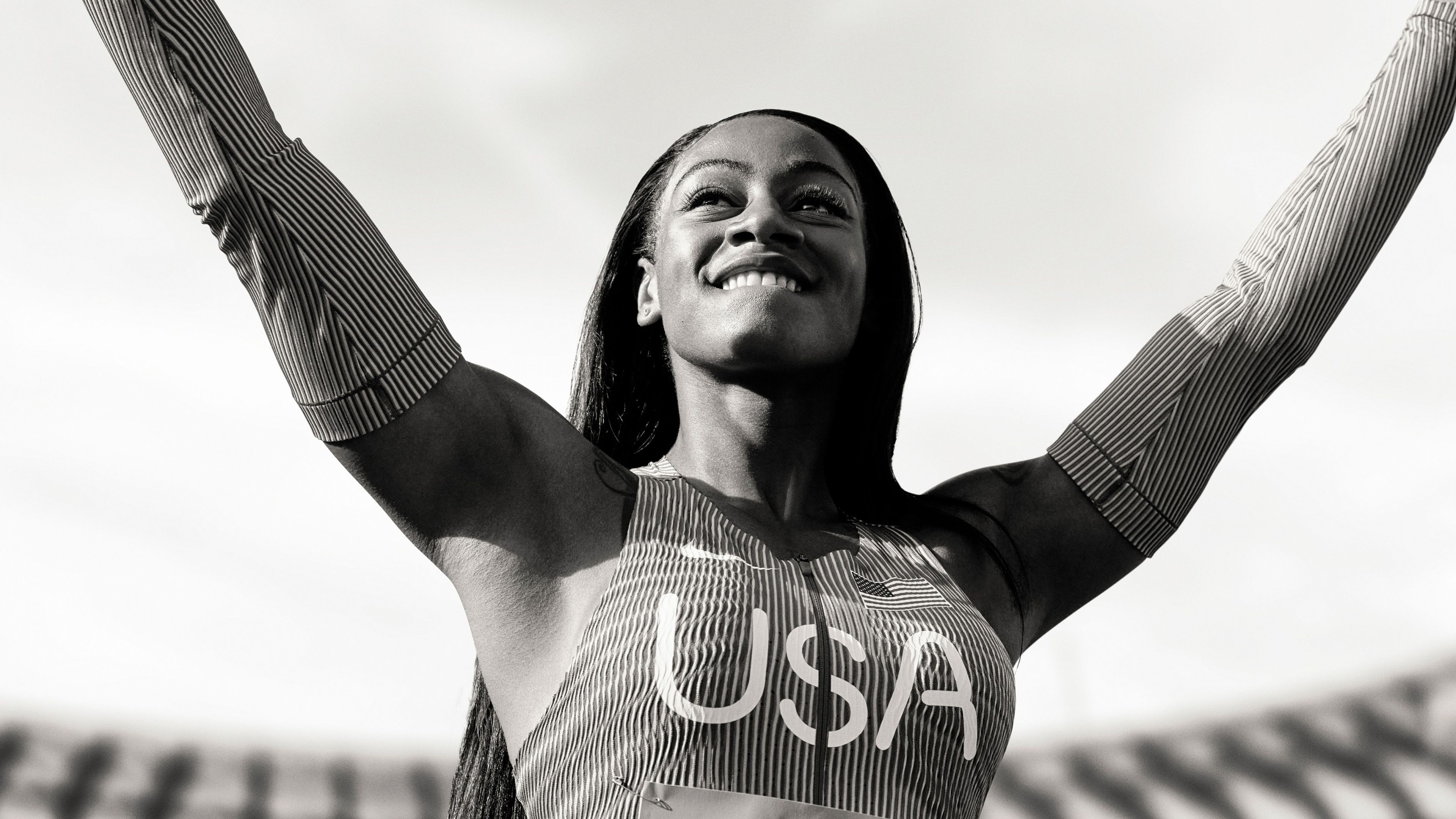 Black and white photo of Sha'Carri Richardson striking a victory pose.