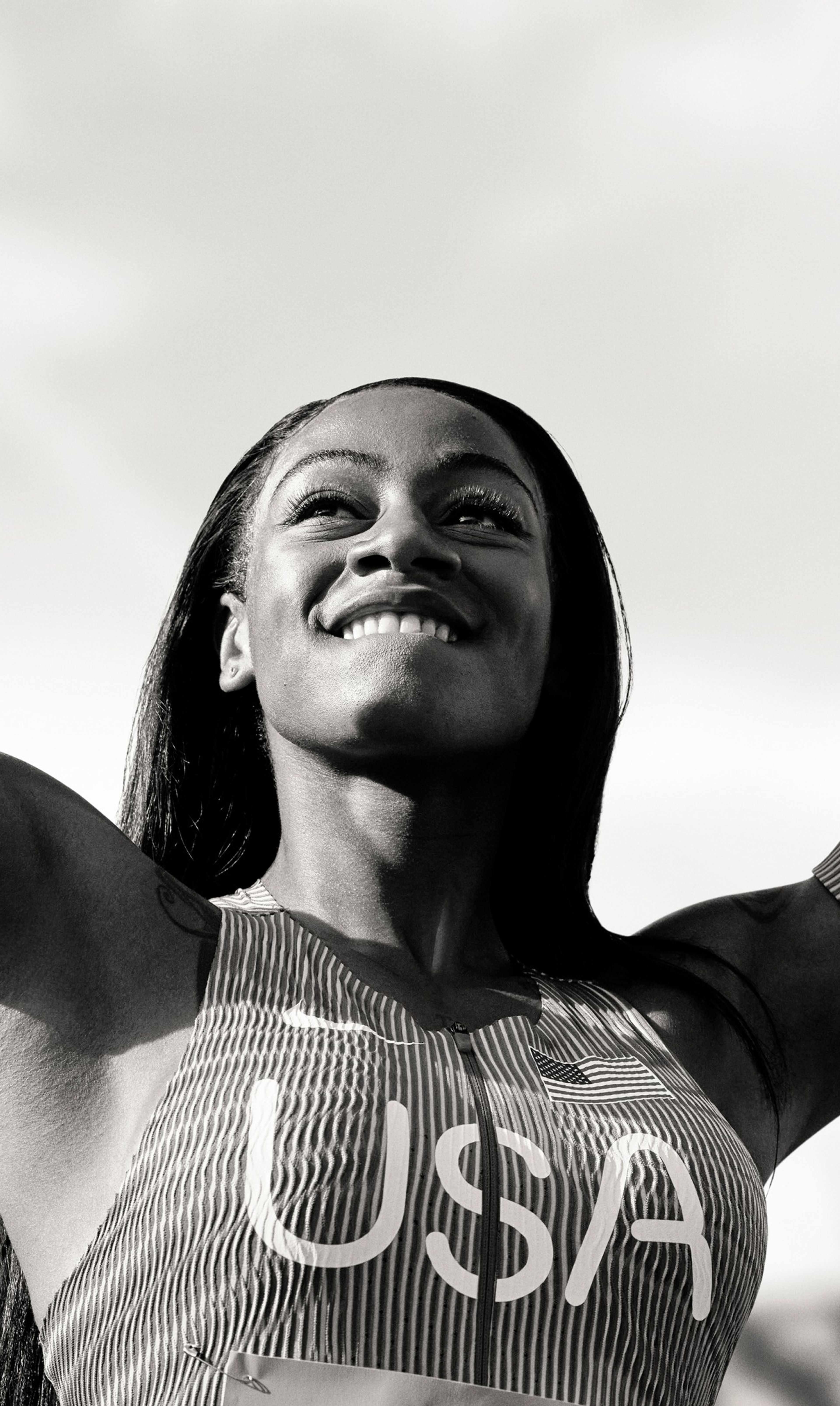 Black and white photo of Sha'Carri Richardson striking a victory pose.
