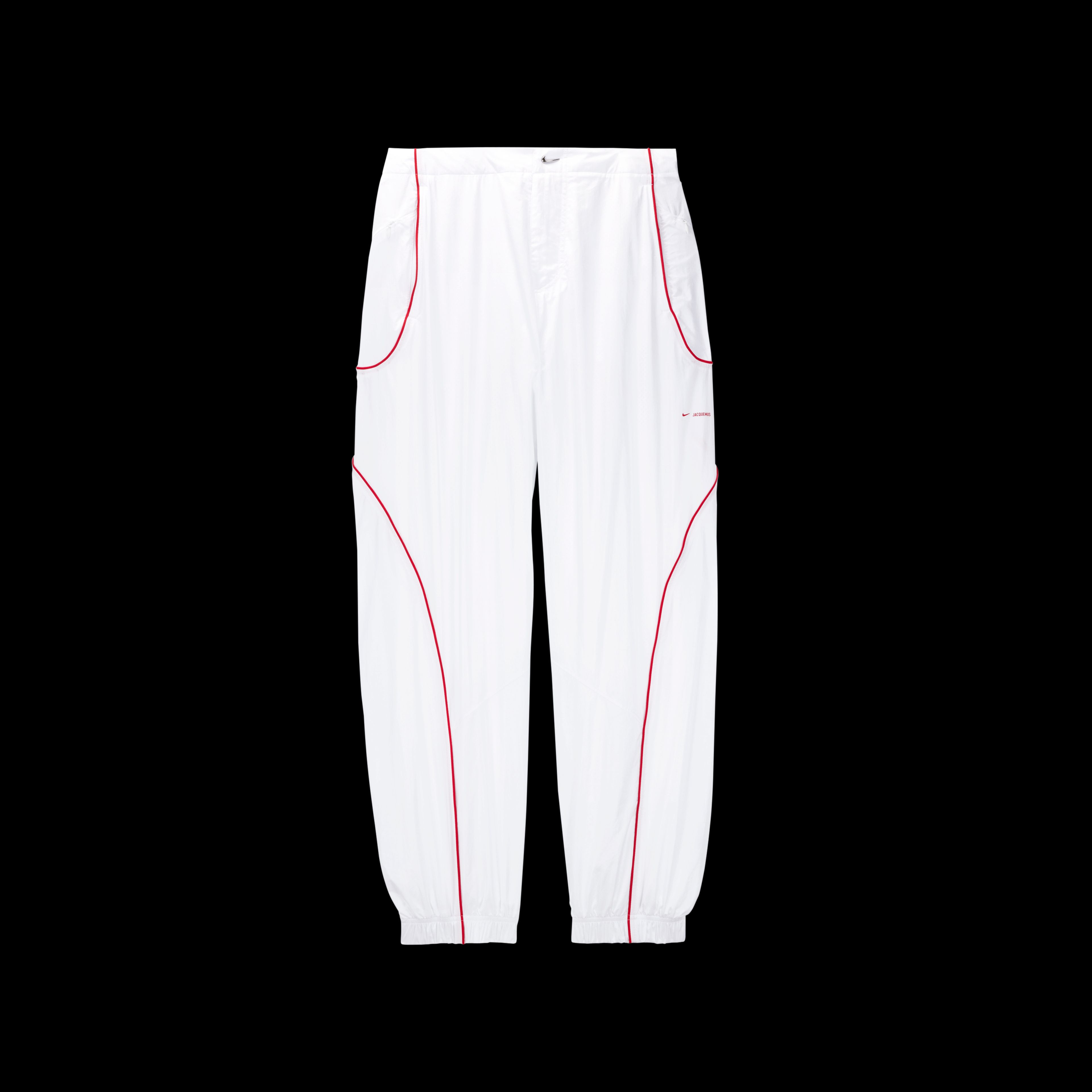 Overhead view of the Nike x Jacquemus Track Pant in white with curved university red pinstripes at the pocket and down the leg. There is a small shiny silver swoosh as a closure on the waist, and elastic cuffs at the ankle. The pant floats on a black background.
