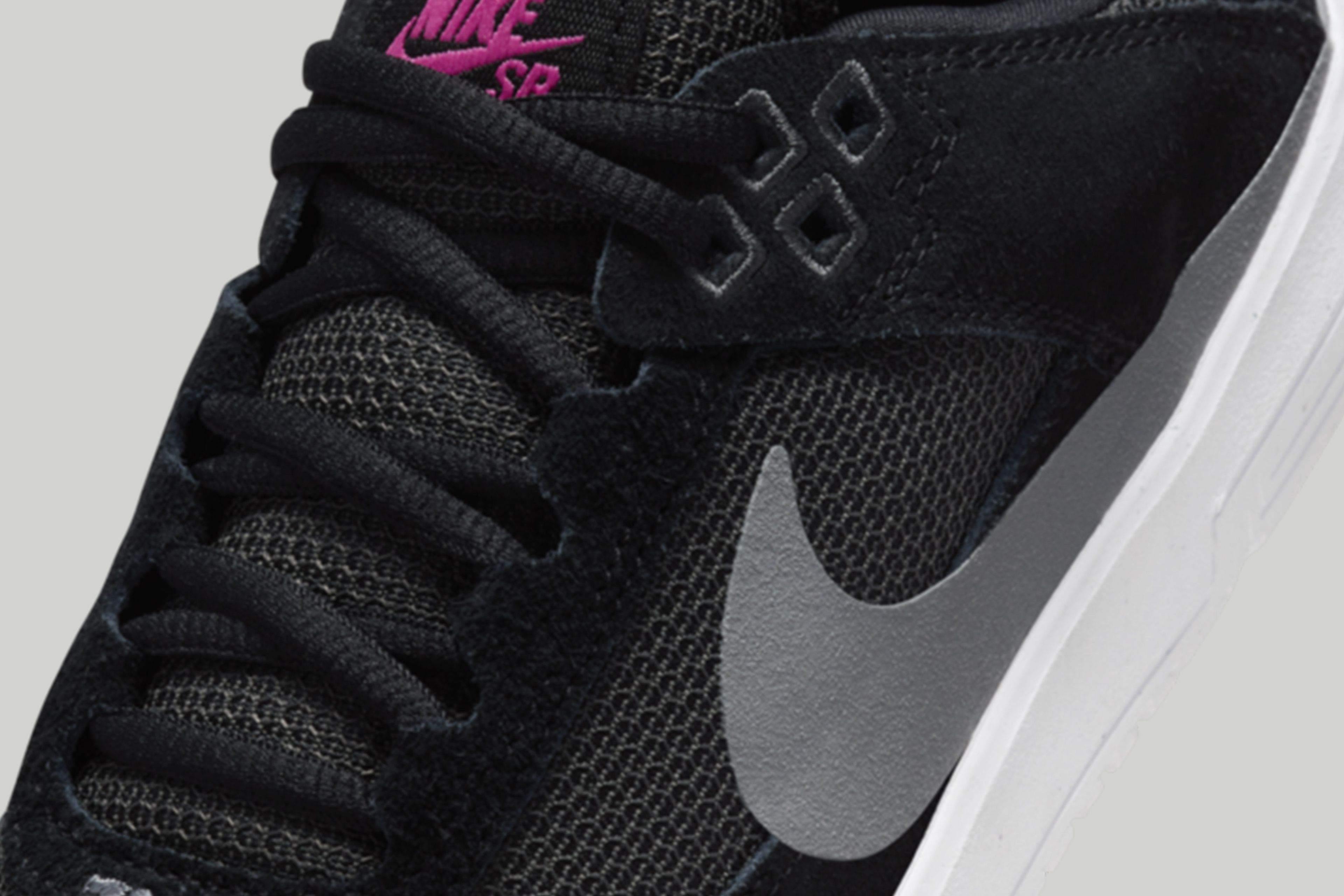 Detail view of the kids Nike SB Day One in black, featuring the upper combination of suede overlays and mesh paneling that helps make them breathable.