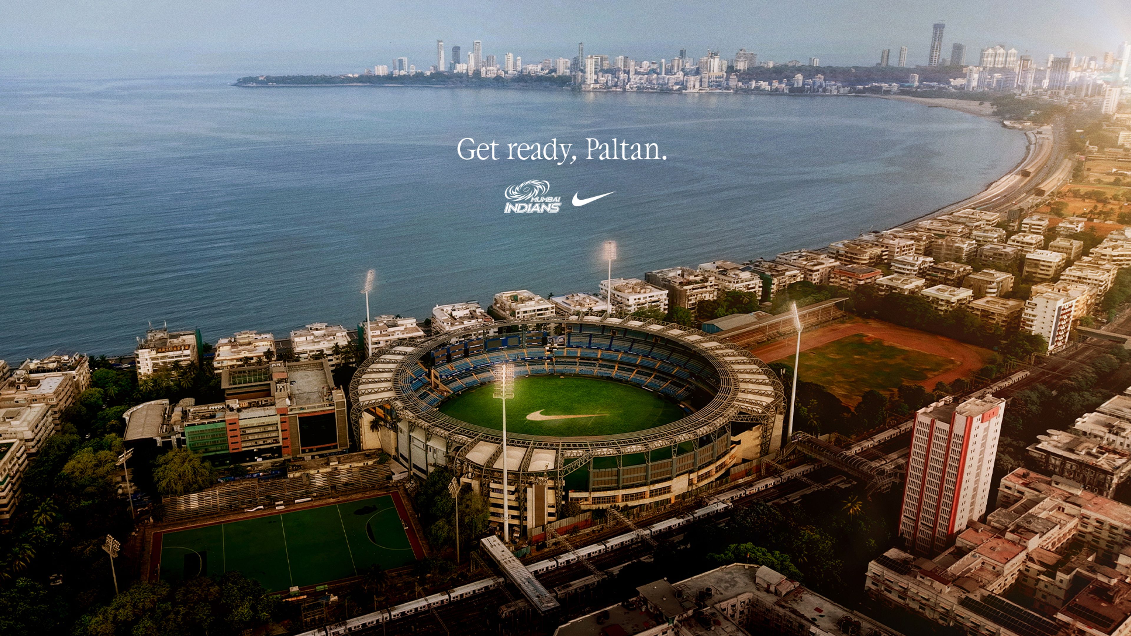 Aerial view of Wankhede Stadium in Mumbai with the Mumbai Indians logo and Nike Swoosh overlaid above