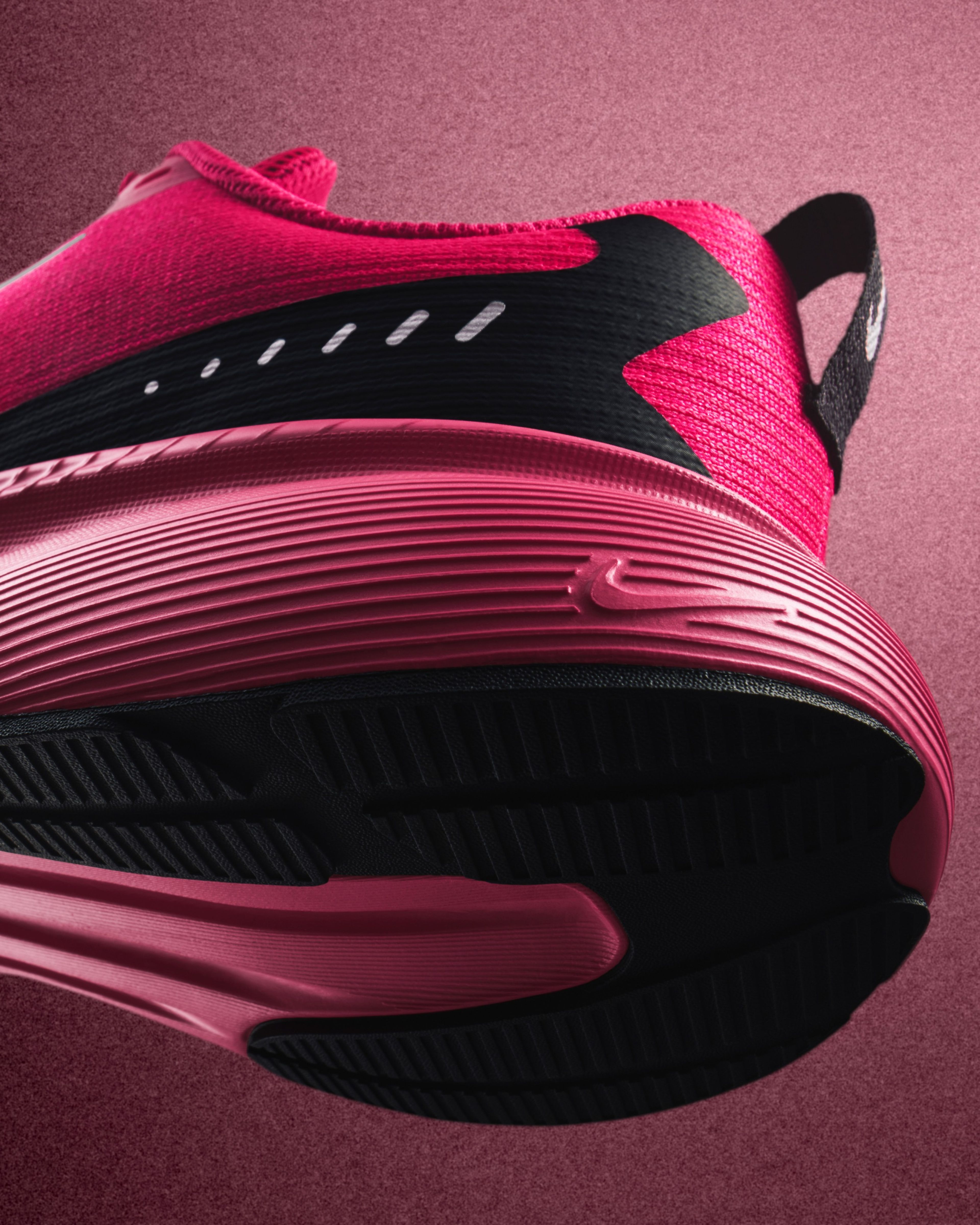 Close-up of the sole of a bright pink Nike Vegam Run shoe