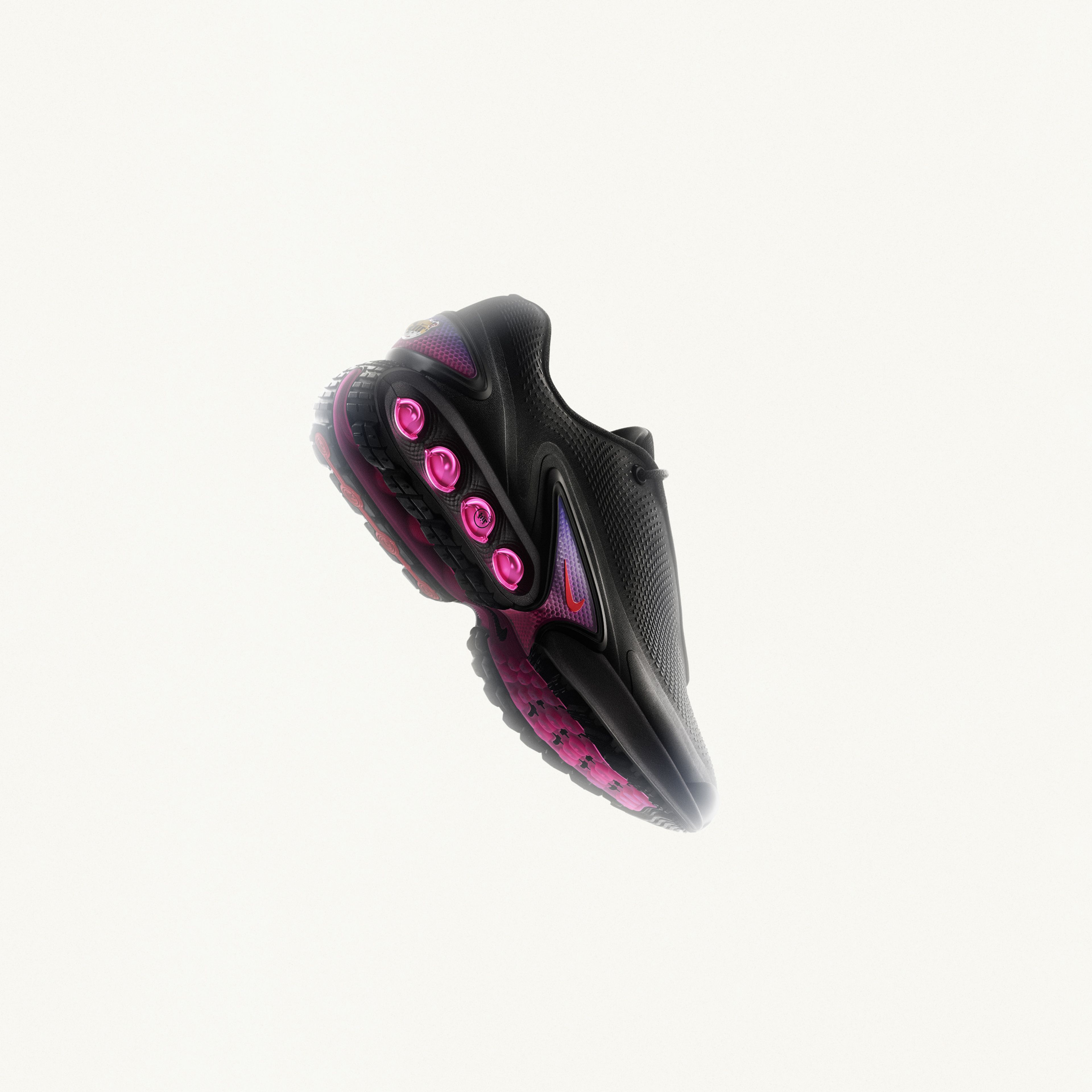 Right angled view of the Nike Air Max Dn in black and dark some grey with light crimson dynamic air unit systems