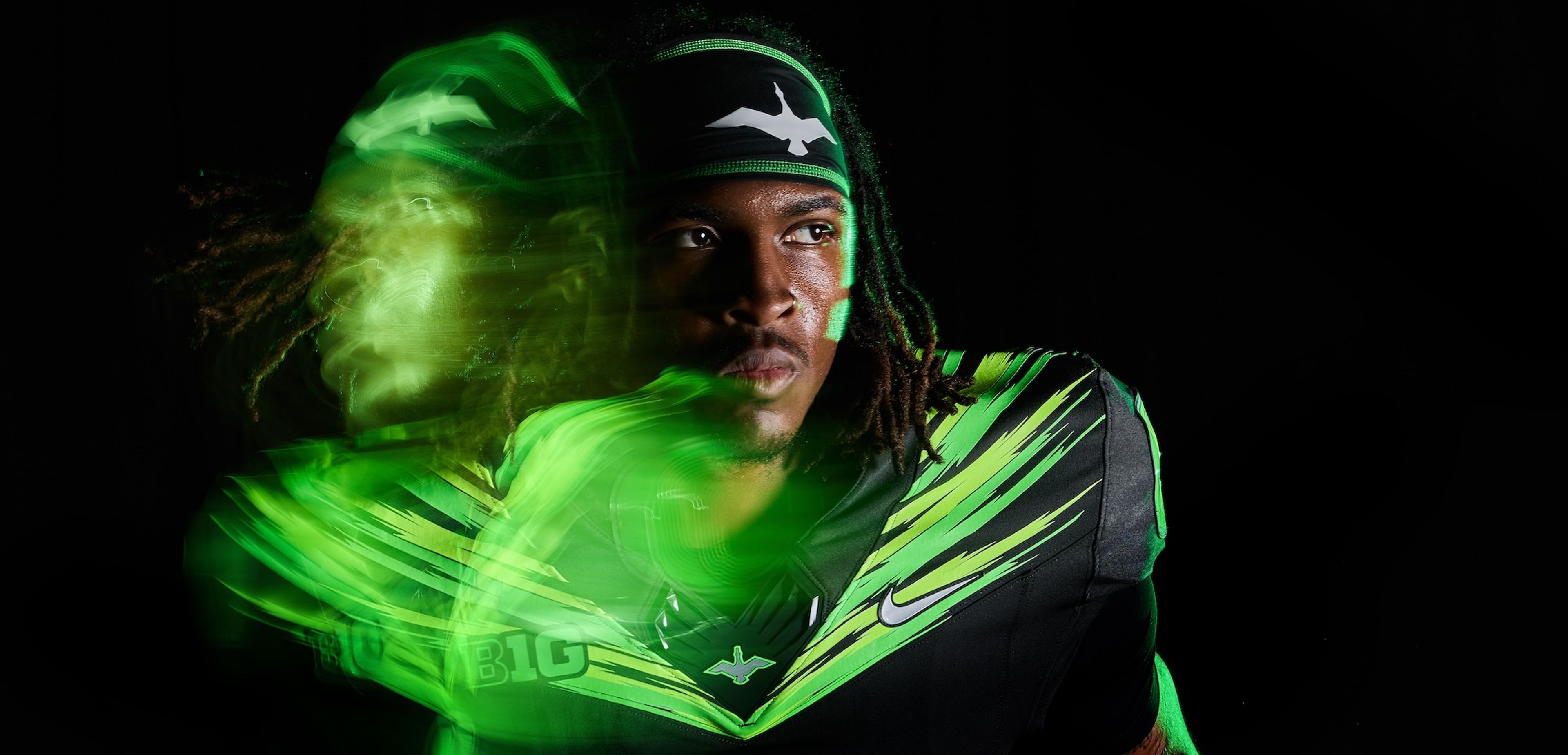 An athlete wearing an Oregon Ducks football uniform with a Nike Swoosh and winged logo.
