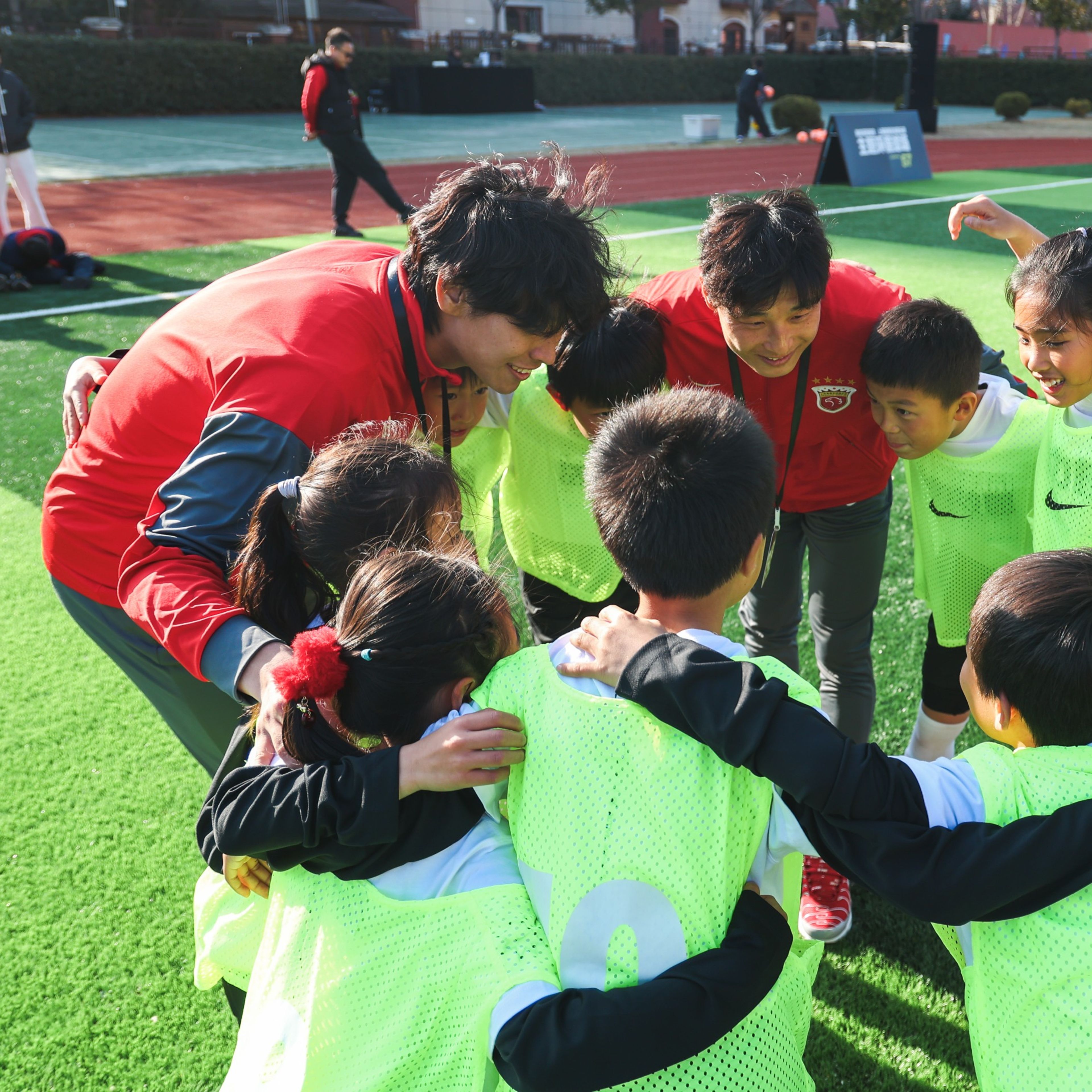 A group of kids huddles with Nike coaches in Haigang, China.