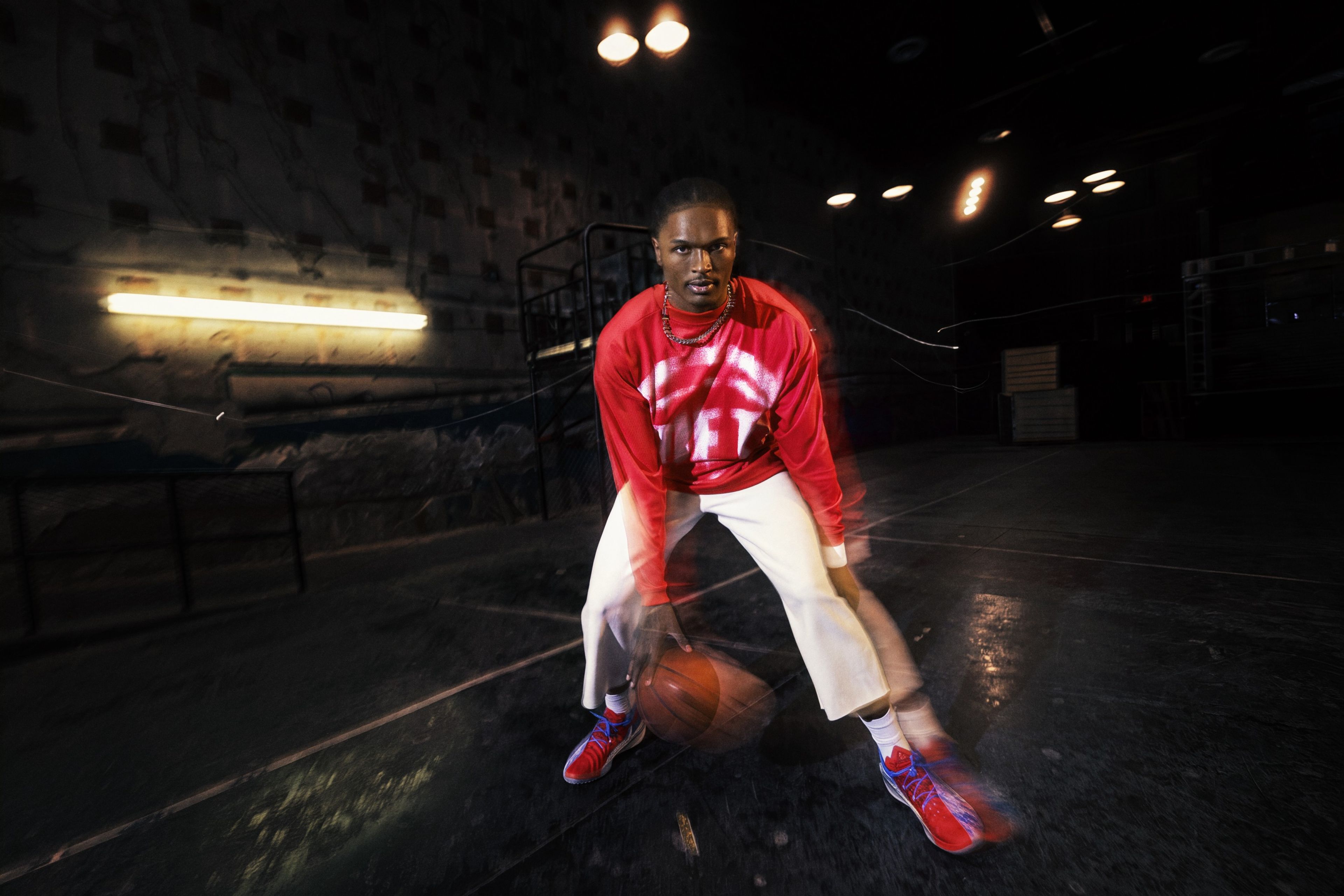 Nike athlete Ausar Thompson is pictured dribbling a basketball between his legs while wearing pieces from Nike’s NBA Standard Issue Collection.