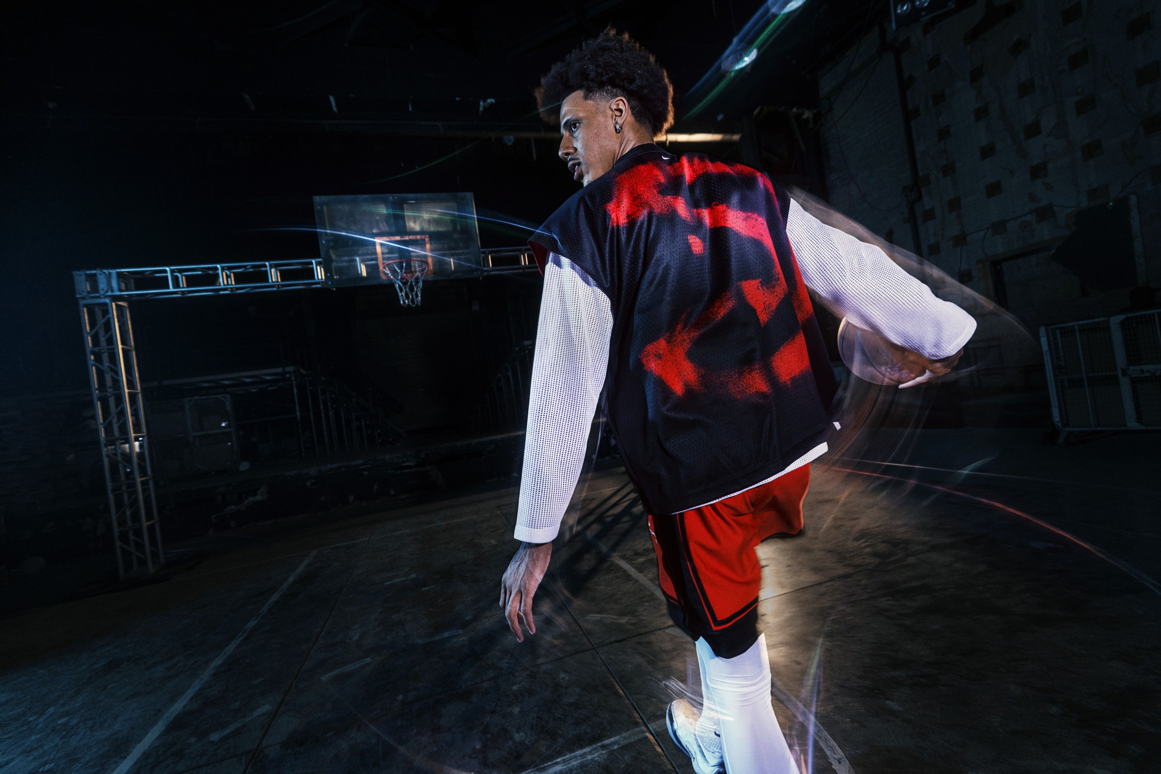 Nike athlete Jalen Johnson dribbles a basketball toward a hoop while wearing pieces from Nike’s NBA Standard Issue Collection.