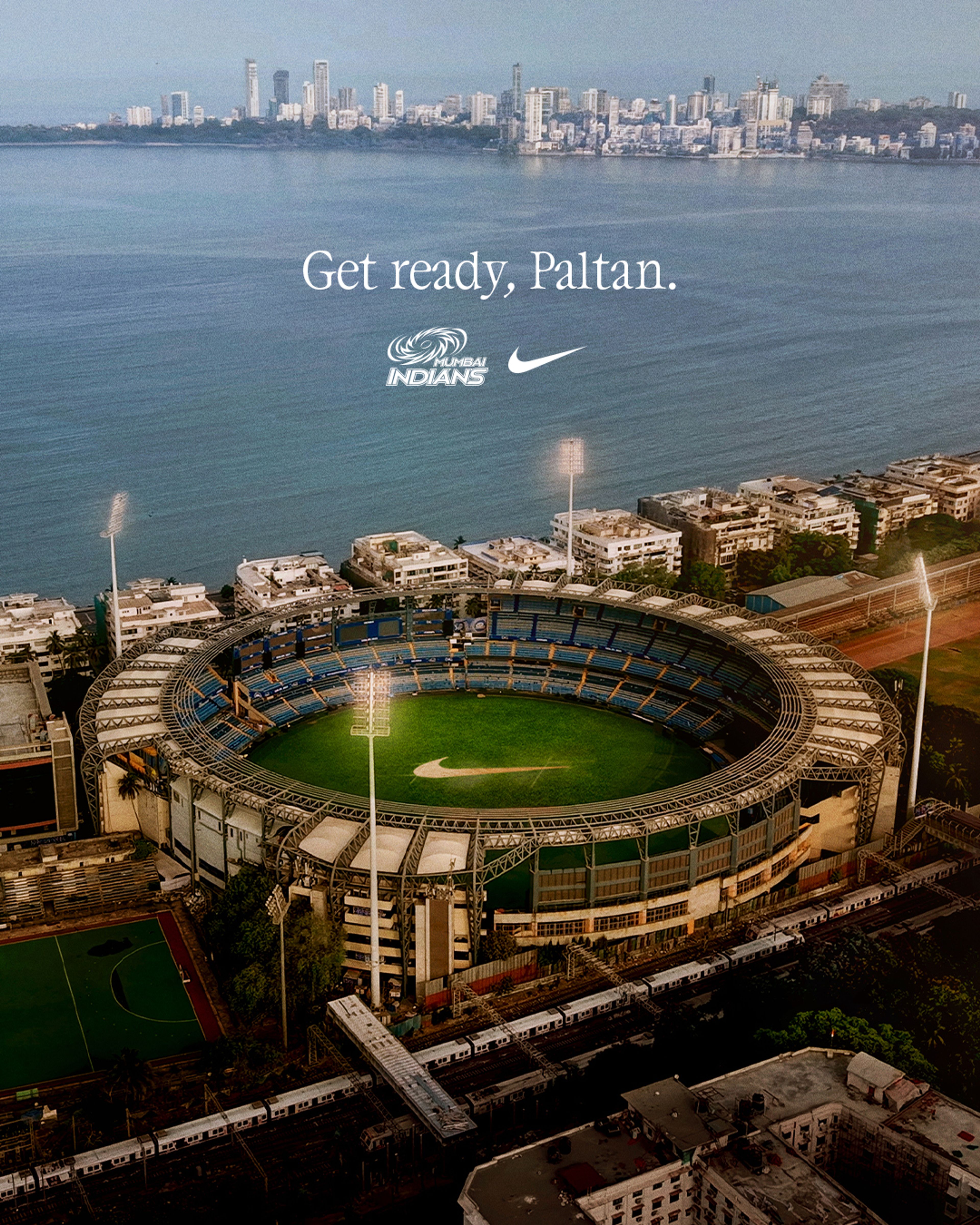 Aerial view of Wankhede Stadium in Mumbai with the Mumbai Indians logo and Nike Swoosh overlaid above