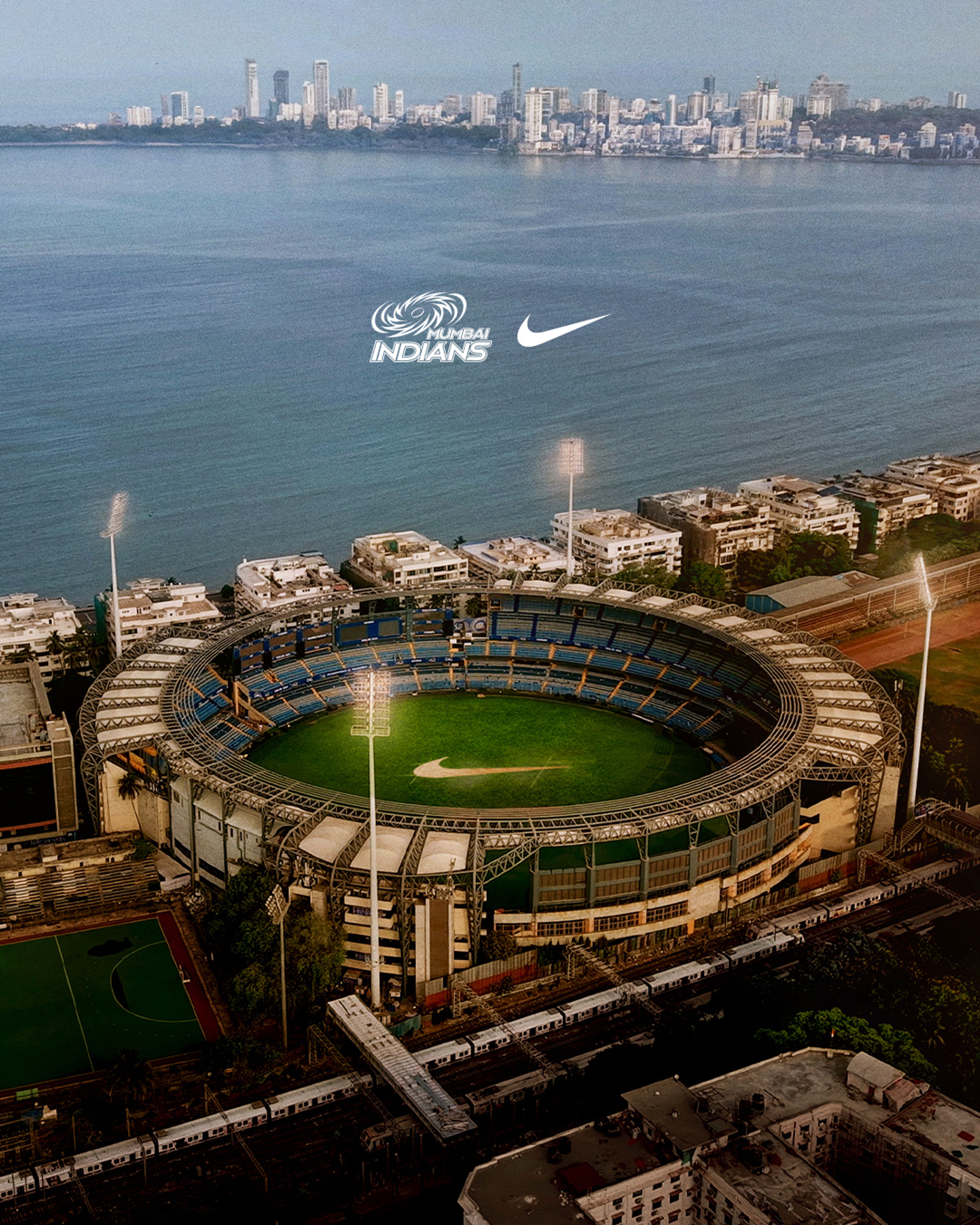 Aerial view of Wankhede Stadium in Mumbai with the Mumbai Indians logo and Nike Swoosh overlaid above